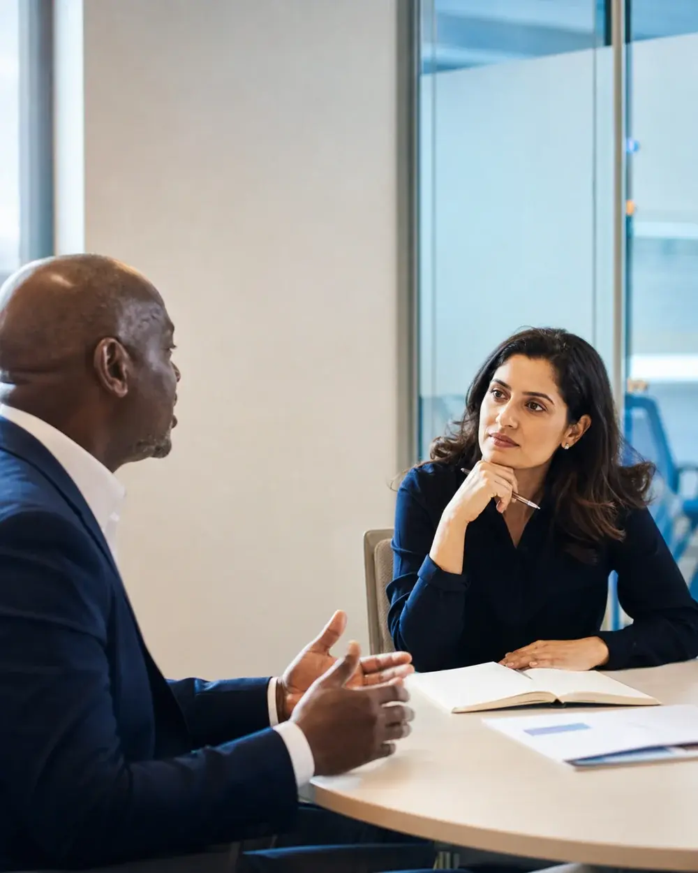 A recruitment consultant listening to a business leader during a workforce planning meeting
